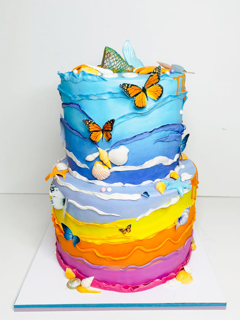 עוגה מעוצבת בקומות עם ים ופרפרים